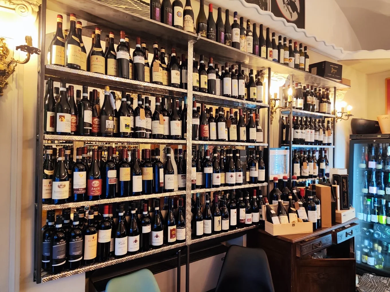 La parete di vini e il banco in legno della Cave d’Antoine