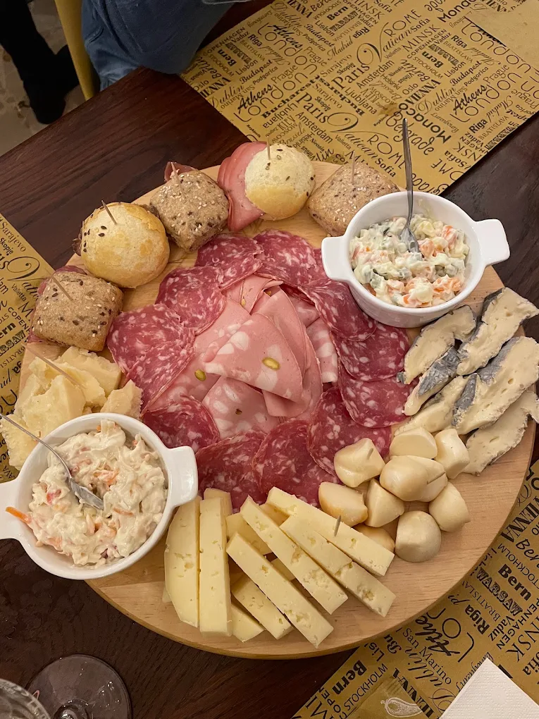 Tagliere di salumi, formaggi e panini sul tavolo del locale